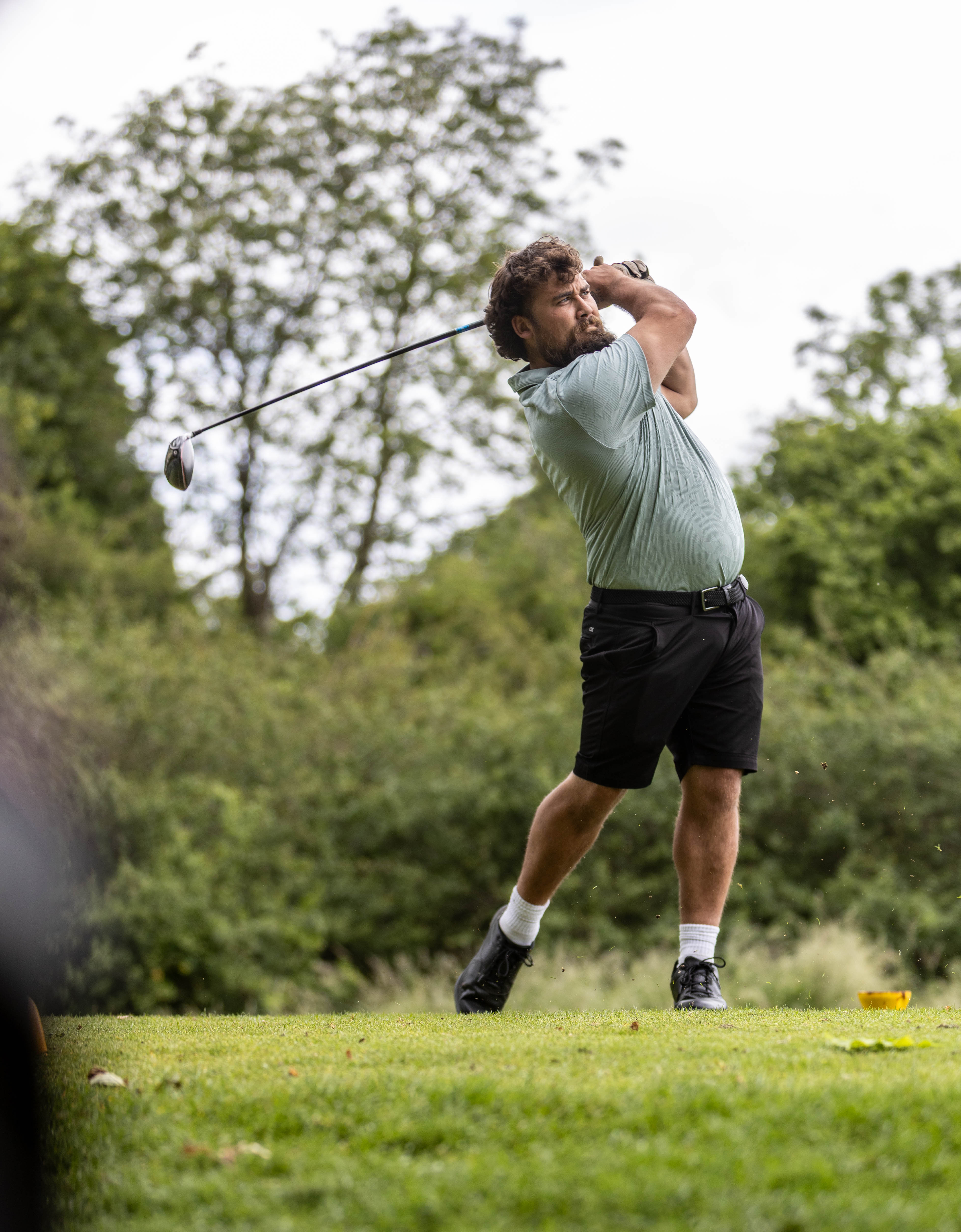 Golfer mid tee shot